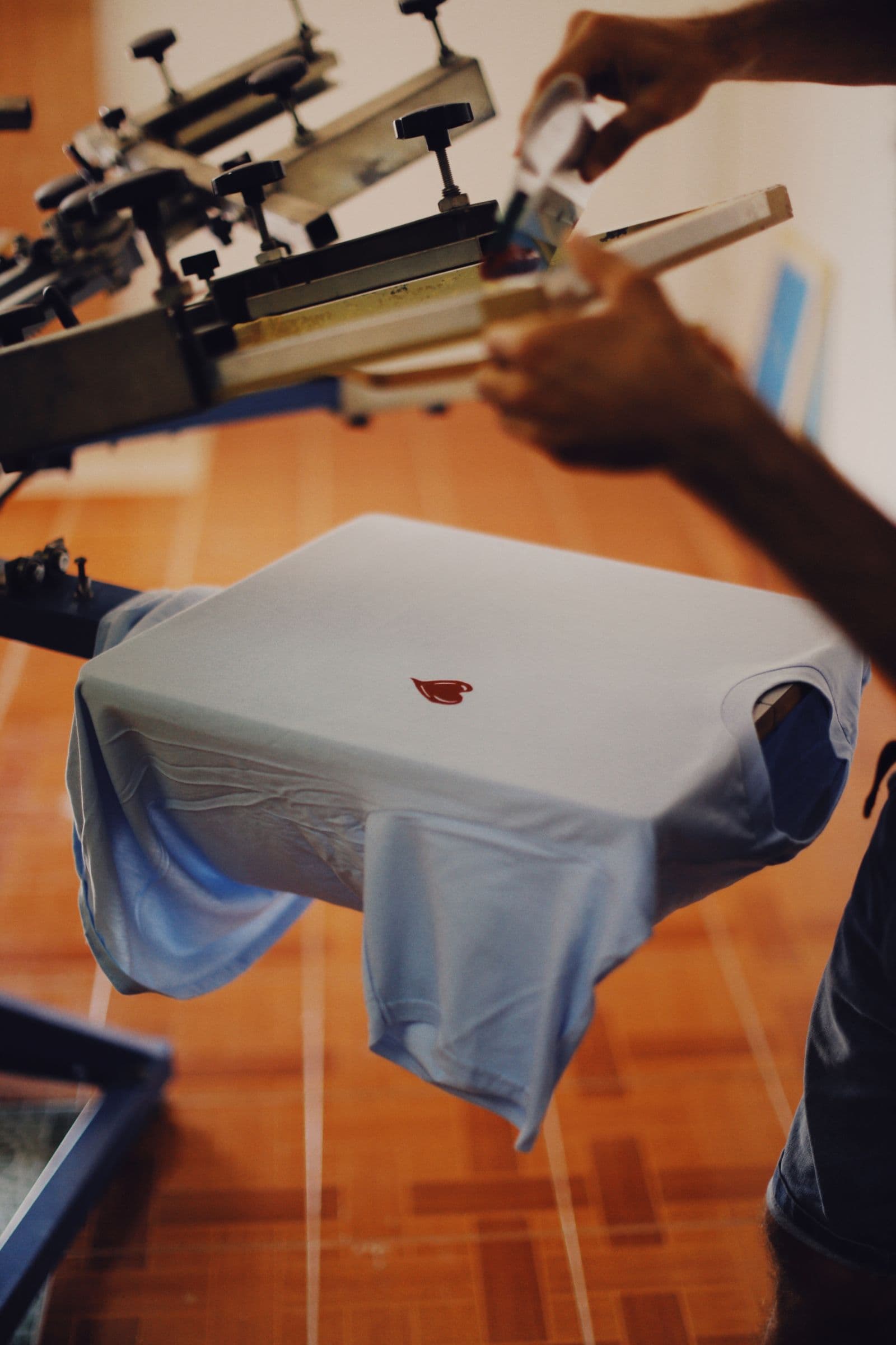 Camiseta blanca preparada en una máquina de serigrafía manual